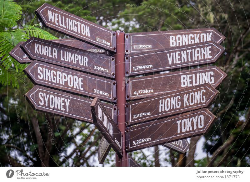 Sign post pointing towards destinations in Asia and Australia Vacation & Travel Tourism Trip Far-off places Earth Wood Exceptional Brown Green sign Malaya City