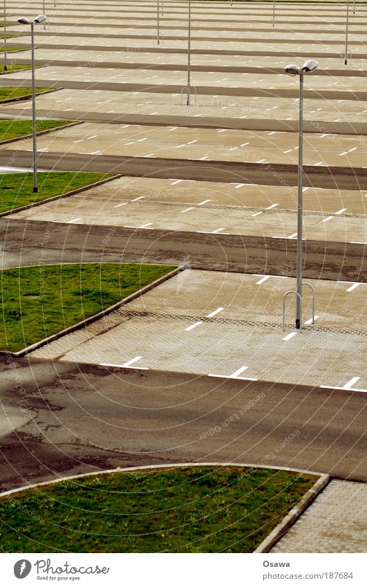 \\\_03 Parking lot Empty Street Road traffic Motor vehicle Parking area grass verge Paving stone Tar Portrait format Exterior shot Gloomy Lantern