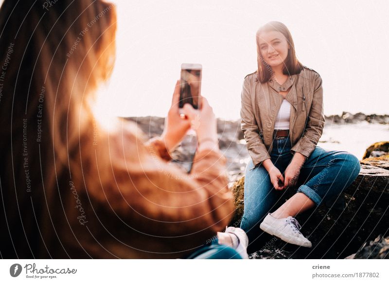 Girl taking photo of her friend with smartphone Lifestyle Joy Vacation & Travel Beach Telephone Cellphone Camera Technology Internet Young woman
