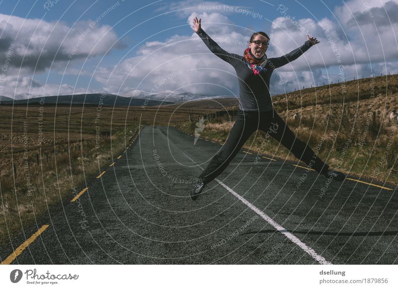 jumping woman on a country road with mountains in the background Feminine Young woman Youth (Young adults) 1 Human being 18 - 30 years Adults Landscape Clouds