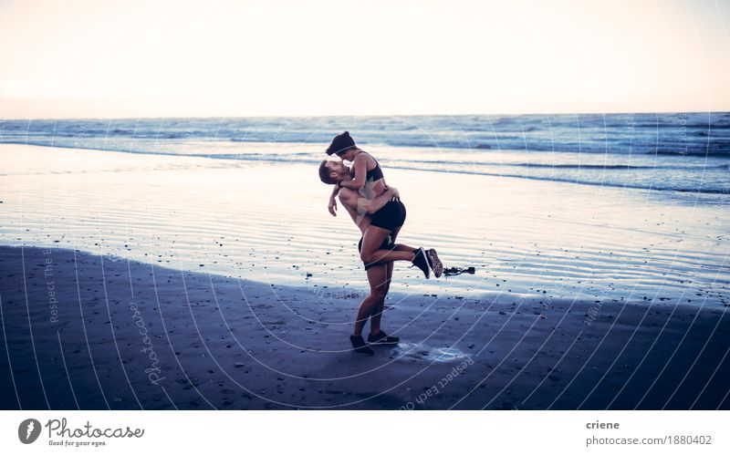 Young adult couple kissing on beach after running workout Lifestyle Joy Body Athletic Fitness Leisure and hobbies Beach Waves Sports Young woman