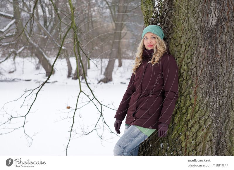 woman leaning against tree in winter landscape Lifestyle Winter Snow Human being Feminine Woman Adults 1 30 - 45 years Nature Tree Park Forest Fashion Jeans