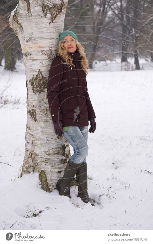 woman leaning against tree in winter Lifestyle Leisure and hobbies Winter Snow Human being Feminine Woman Adults 1 30 - 45 years Nature Tree Park Forest Fashion