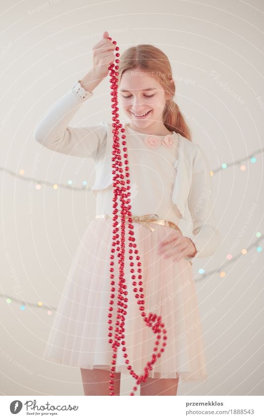 Portrait of young girl unwrapping red Christmas decorations Lifestyle Joy Happy Decoration Feasts & Celebrations Christmas & Advent Human being Girl