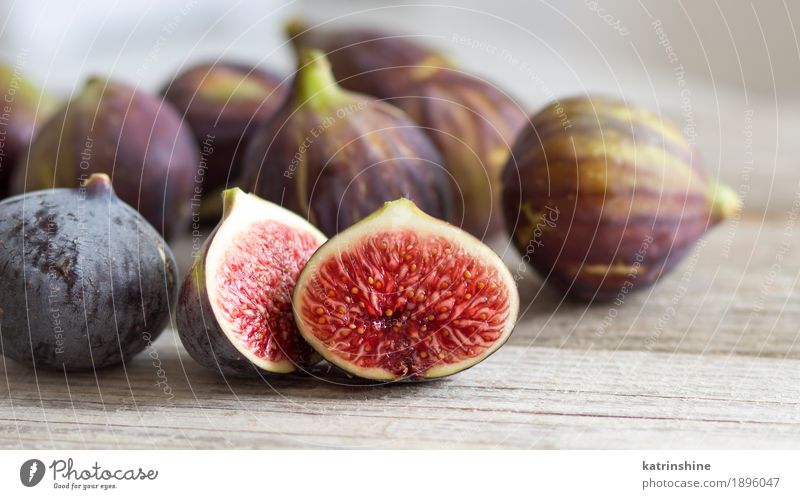 Fresh fruits - figs on the wooden table Fruit Diet Exotic White background close Cut Fig food Organic Purple ripe seed Slice sweet Consistency Vitamin Wedge