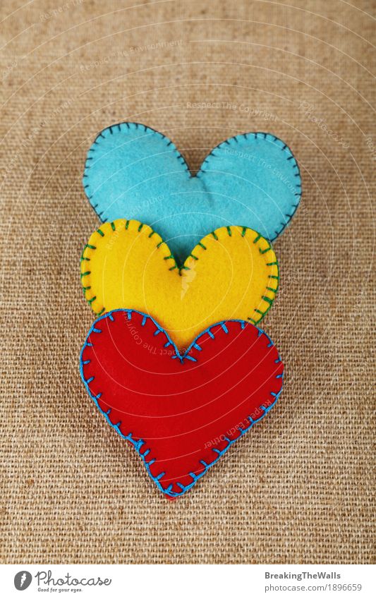 Three handmade felt hearts, yellow, red and blue on canvas Leisure and hobbies Handicraft Handcrafts Family & Relations Art Cloth Heart Love Together Natural