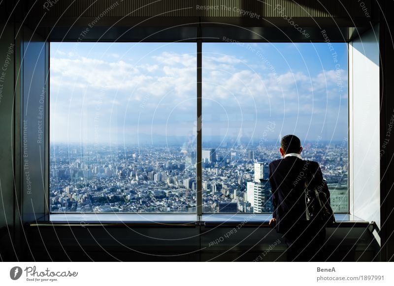 Man in suit stands in front of window with view over Tokyo, Japan Business Loneliness Horizon Town Asia Businessman City Smog Architecture Large Clouds Contrast