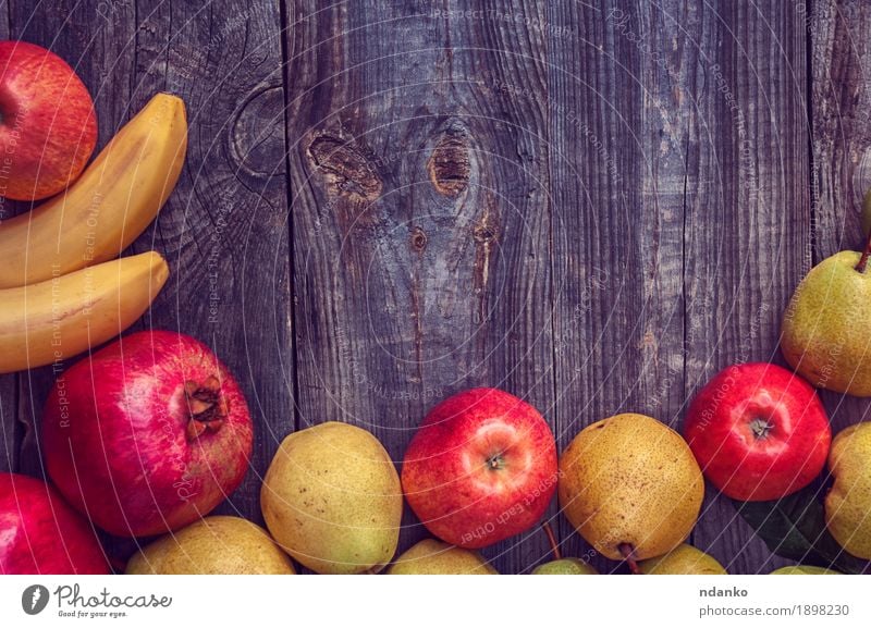 Bananas, pomegranates, apples and pears on a gray wooden surface Fruit Apple Organic produce Vegetarian diet Garden Table Autumn Wood Fresh Natural Above Juicy