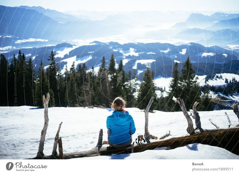 Woman sitting on a tree trunk at a pointed stone and looking into the Inn valley Relaxation Vacation & Travel Winter Adults Nature Fitness Contentment