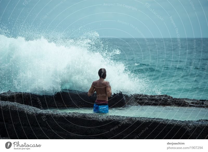 Eco shower. A man stands on the beach and a wave crashes over him. One day in January on Pacific Joy Fitness Wellness Leisure and hobbies Trip Aquatics