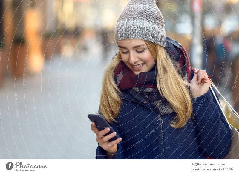 Fashionable young woman busy with her mobile phone Lifestyle Beautiful Reading Winter Telephone PDA Technology Woman Adults 1 Human being 18 - 30 years