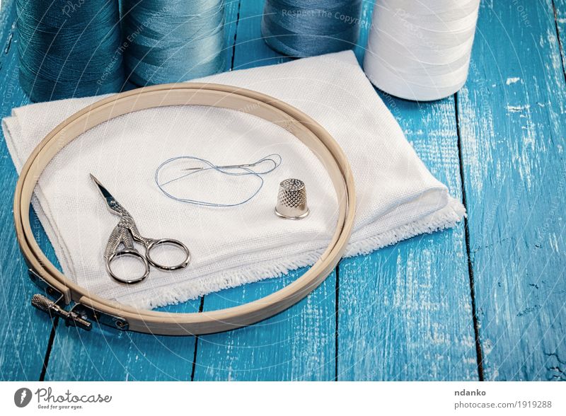 Flat lay composition with sewing accessories: threads, red and gray  fabrics, scissors, buttons, set of needles, pins and other sewing tools on  a white background. Top view, copy space, mock up. 