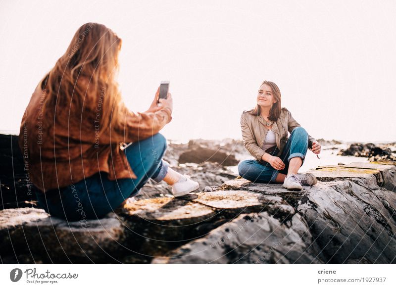 Teenager girl taking photo with smartphone of her friend Lifestyle Joy Beach Ocean Telephone Cellphone PDA Camera Technology Entertainment electronics Internet