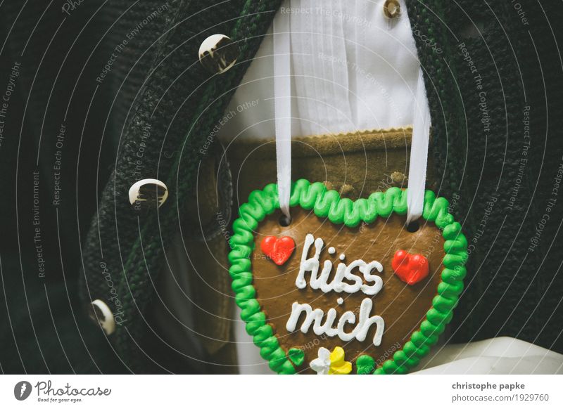 Gingerbread heart with inscription "Kiss me" on Bavarian costume Heart Oktoberfest Event Infatuation Valentine's Day Fairs & Carnivals Feasts & Celebrations