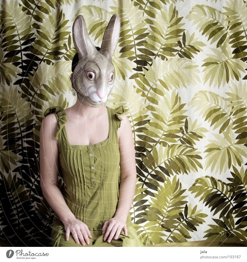 Apathetic sitting around Human being Feminine Woman Adults Sit Green Hare & Rabbit & Bunny Mask Easter Carnival costume Colour photo Interior shot Day