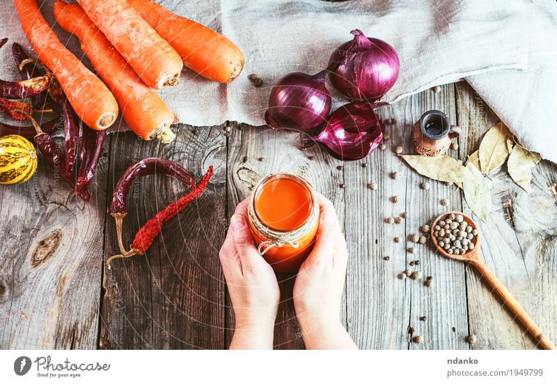 female hands holding a jar with a glass of fresh carrot juice Vegetable Herbs and spices Nutrition Eating Drinking Juice Bottle Spoon Body Skin Table Kitchen