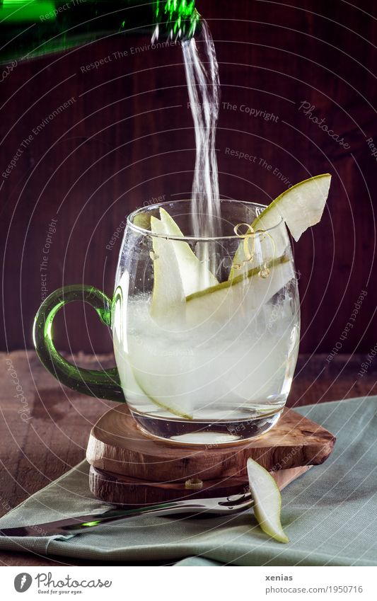 fresh water with pear slices, mineral water pours into a glass with pear slices against a dark background Pear Drinking water Fruit Beverage Cold drink Bottle