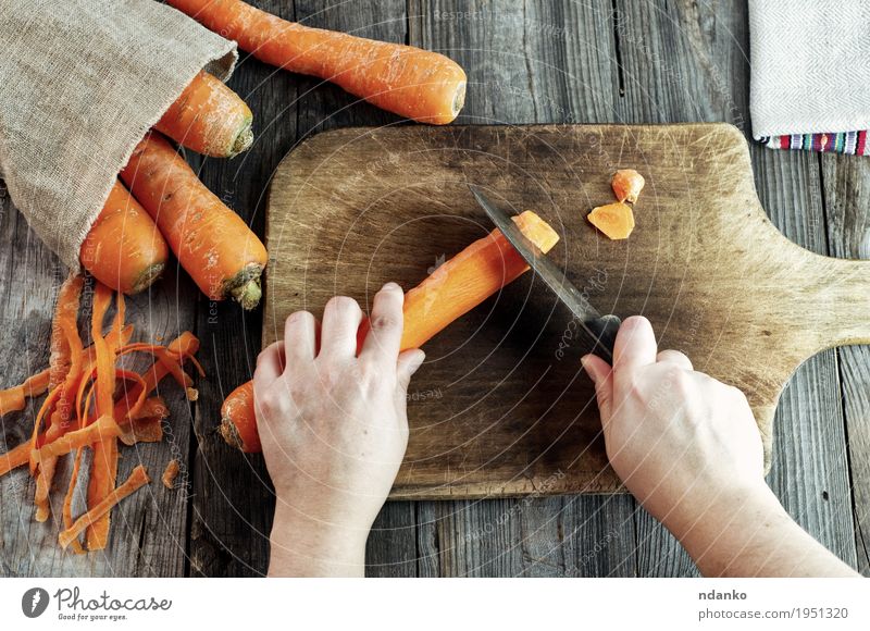 process of cutting slices of carrot on a kitchen board Food Vegetable Nutrition Vegetarian diet Diet Knives Body Healthy Eating Table Woman Adults Hand Fingers