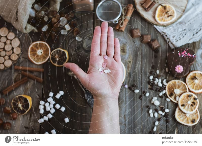 Open human palm on the background of the table with sweets Fruit Orange Cake Dessert Candy Chocolate Eating Spoon Decoration Table Restaurant Woman Adults Arm