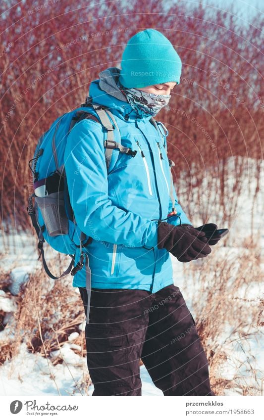 Boy using the mobile phone during the winter trip Lifestyle Joy Vacation & Travel Trip Adventure Freedom Expedition Winter Snow Winter vacation Hiking Sports