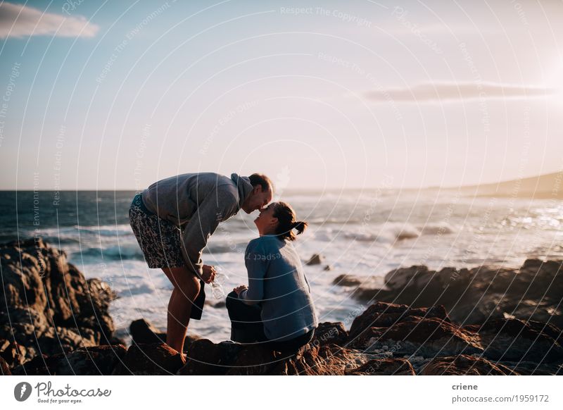 Young adult caucasian couple kissing on cliff at ocean Lifestyle Joy Vacation & Travel Tourism Trip Adventure Beach Ocean Flirt Young woman Youth (Young adults)