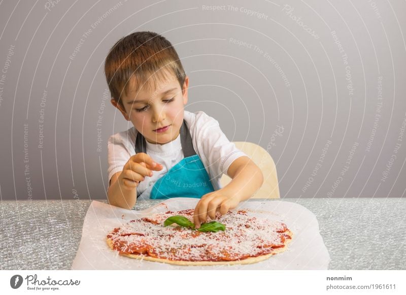 Little boy is making pizza, finishing with basil leafs Cheese Dough Baked goods Bowl Beautiful Leisure and hobbies Kitchen Child School Boy (child) Infancy Hand