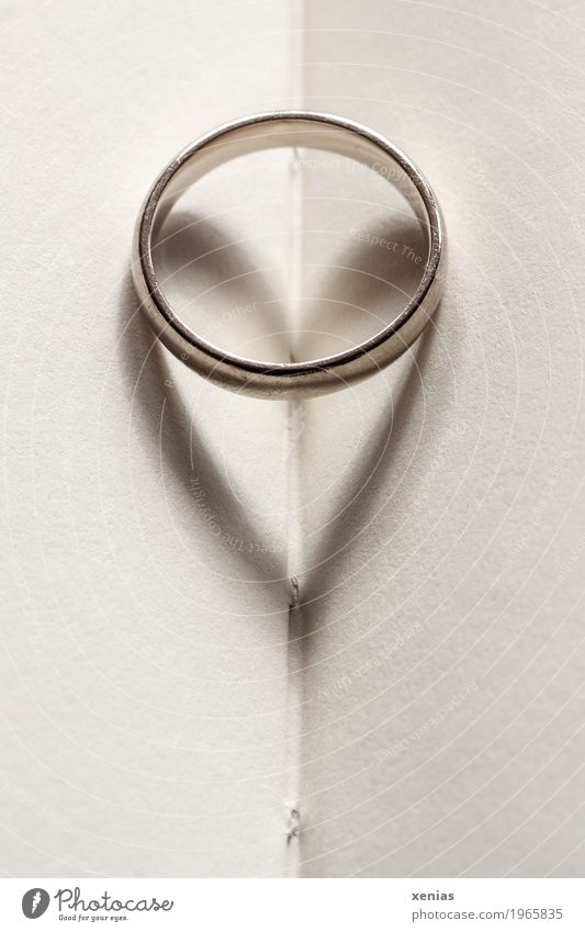 Ring with heart as shadow lies on paper Book Wedding band Jewellery Heart Paper Page Gold Silver White Love Attachment Gold alloy Heart-shaped Matrimony Card