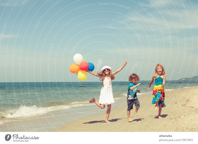 Three happy children with balloons dancing on the beach Lifestyle Joy Happy Beautiful Relaxation Leisure and hobbies Playing Vacation & Travel Freedom Summer
