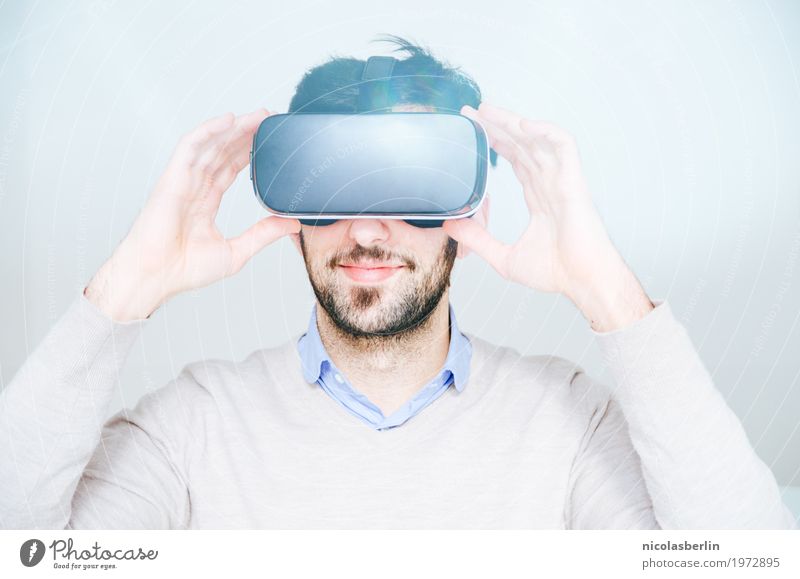Young man wearing VR glasses and smiling on white background Virtual Joy Smiling virtual reality virtual reality simulator Playing Computer games Success Office