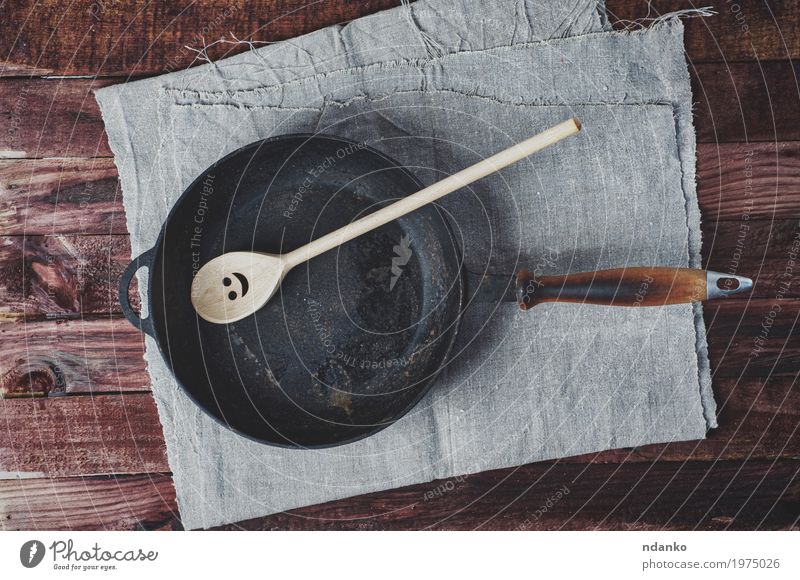 Frying pan frying pans and a wooden paddle Crockery Pan Spoon Table Kitchen Restaurant Tool Cloth Wood Metal Above Clean Brown Black tableware Tablecloth
