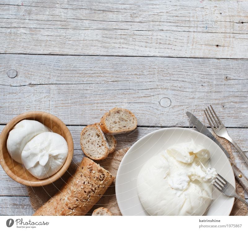 Italian cheese burrata with bread on a wooden background Cheese Dairy Products Dough Baked goods Bread Nutrition Vegetarian diet Italian Food Plate Bowl Fork