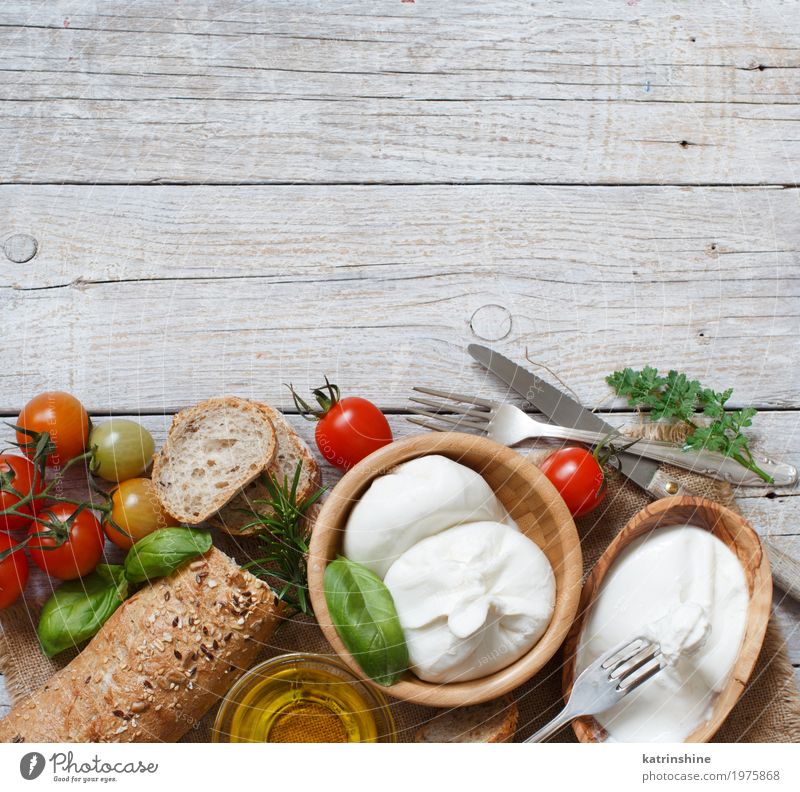 Italian cheese burrata with bread, vegetables and herbs Cheese Dairy Products Vegetable Bread Herbs and spices Nutrition Vegetarian diet Italian Food Bowl Fork