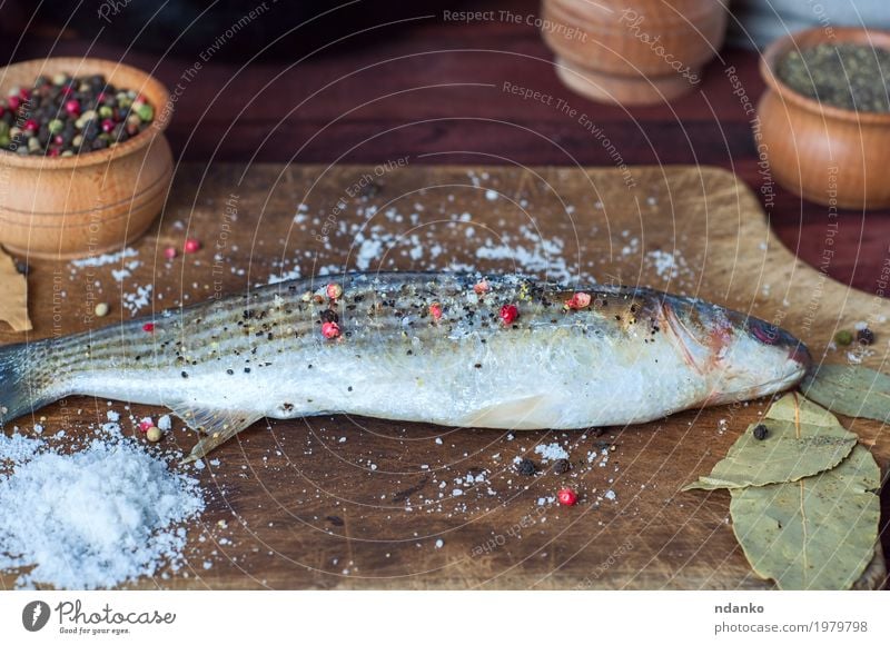 Fresh smelt fish in spices for cooking on a kitchen board Fish Herbs and spices Nutrition Eating Diet Table Kitchen Wood Above Brown White pepper paprika whole