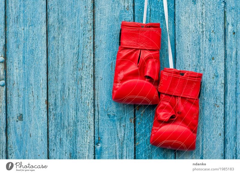 pair of red boxing gloves hanging on a nail Sports Sporting event Success Gloves Wood Old Hang Retro Blue Red Competition Object photography Kick copy power