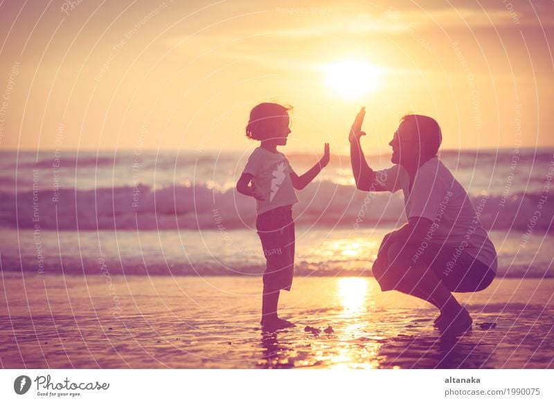 Father and son playing on the beach at the sunset time. Concept of friendly family. Lifestyle Joy Leisure and hobbies Playing Vacation & Travel Trip Freedom