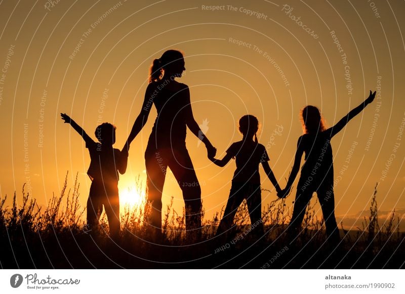 Happy family standing in the park at the sunset time. Lifestyle Joy Beautiful Leisure and hobbies Playing Vacation & Travel Trip Freedom Camping Summer Sun