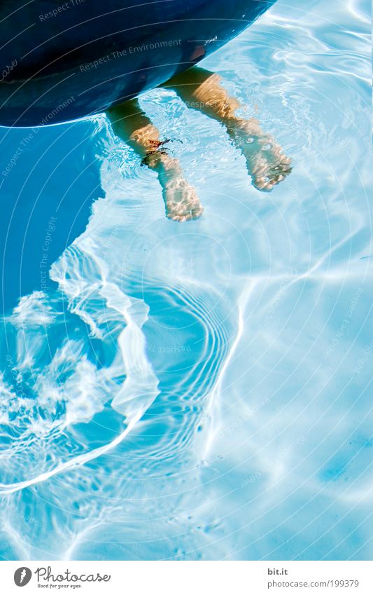 Two Naked Feet Dive In The Blue Water Under A Big Blue Swimming Ring A Royalty Free Stock