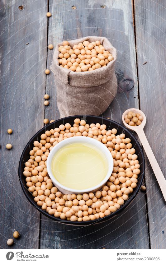 Soy beans and soy oil in bowls on wooden table Nutrition Organic produce Vegetarian diet Asian Food Bowl Spoon Container Wood Fresh Healthy Natural Beans Fiber