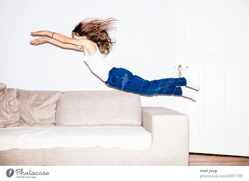 Long haired girl in jeans jumps headfirst into a sofa Feminine Child 8 - 13 years Infancy Jeans Brunette Long-haired Flying Jump Brash Happiness Infinity Funny