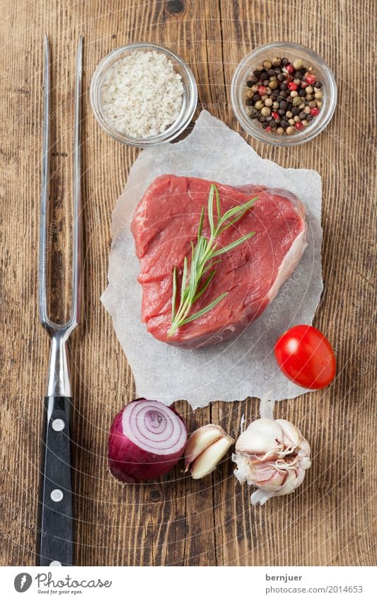 raw steak on wood Meat Herbs and spices Fork Paper Wood Fresh Red White Raw Fished Steak beef steak Garlic Tomato Onion Salt Carving fork Pepper Rustic boil