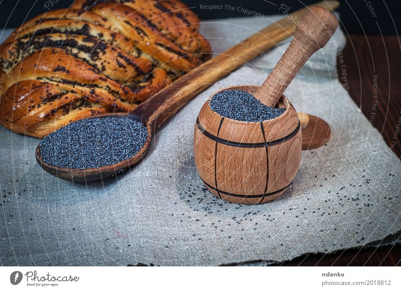 Poppy seeds in a wooden mortar Roll Dessert Herbs and spices Nutrition Bowl Spoon Wood Fresh Natural Brown Black rolls pastries Heap grain agriculture sweet