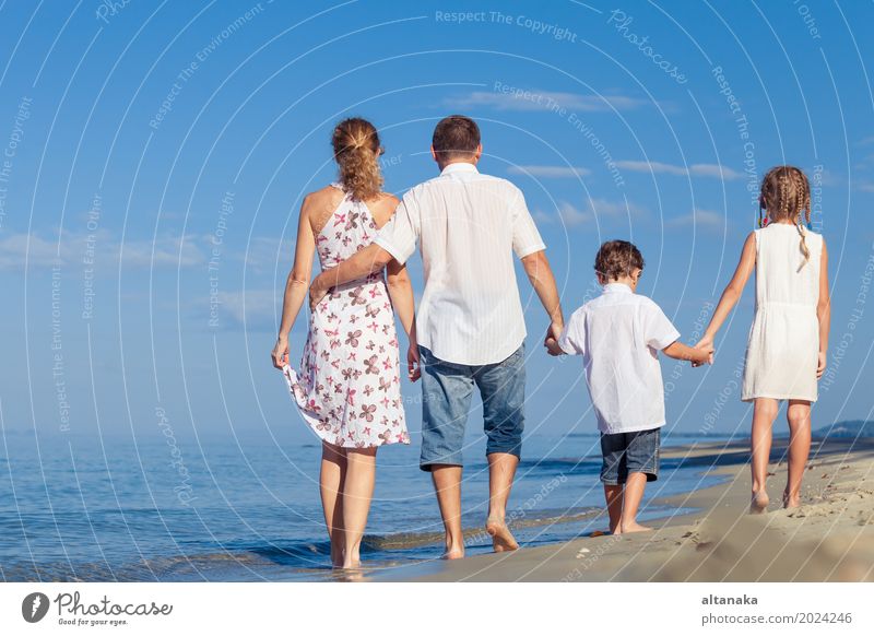 Happy family walking on the beach at the day time. Concept of friendly family. Lifestyle Joy Relaxation Leisure and hobbies Playing Vacation & Travel Trip