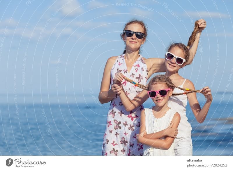 Mother and children playing on the beach at the day time. Concept of friendly family. Lifestyle Joy Relaxation Leisure and hobbies Playing Vacation & Travel