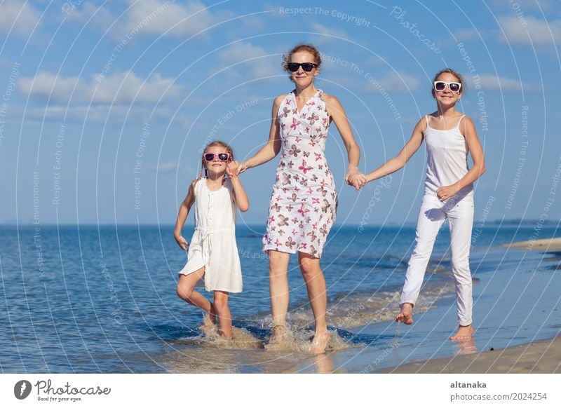 Mother and children playing on the beach at the day time. Concept of friendly family. Lifestyle Joy Relaxation Leisure and hobbies Playing Vacation & Travel