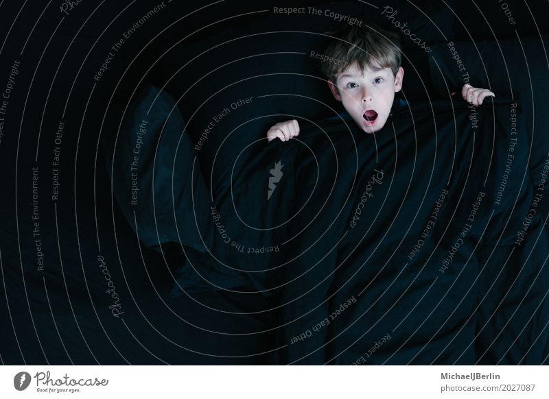 Boy with a shocked look under a black blanket Human being Masculine Child Head 1 3 - 8 years Infancy Black Emotions Concern Fear Horror Disbelief Bed Ceiling
