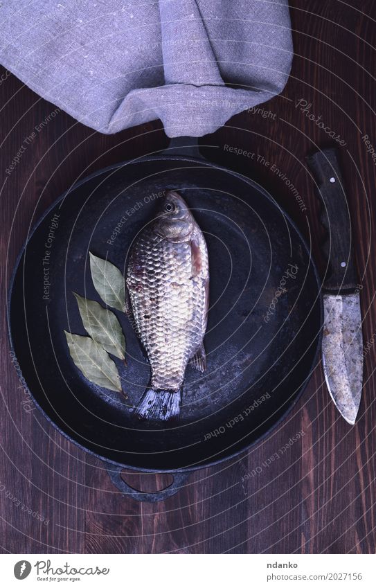 Fresh river carp in a black cast-iron frying pan Fish Herbs and spices Diet Pan Knives River Wood Eating Above Retro Brown crucian food cook Live vintage Edible