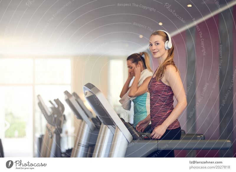 Attractive Woman with headphones on treadmill in the gym Lifestyle Happy Beautiful Face Leisure and hobbies Sports Adults 2 Human being 18 - 30 years