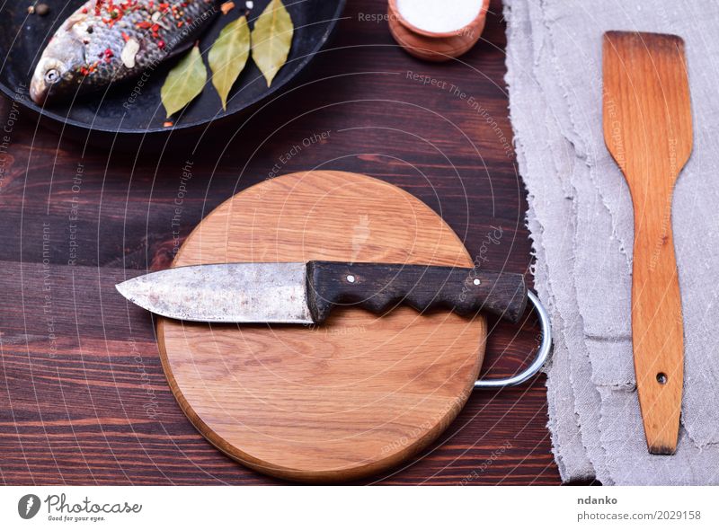 Kitchen knife on a circular cutting wooden board Fish Eating Pan Knives Table Old Retro Brown Gray Black Knife Top Carp spatula napkin cook frying pan food