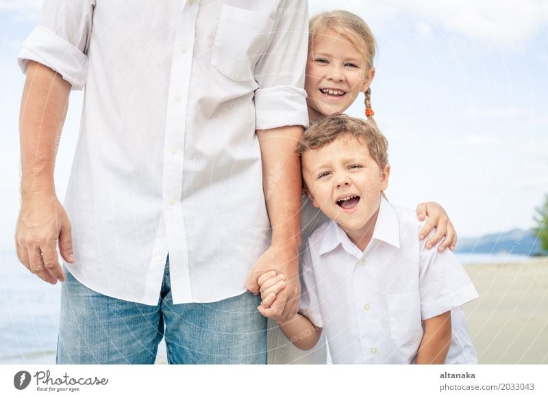 Father and children playing on the beach at the day time. Concept of friendly family. Lifestyle Joy Relaxation Leisure and hobbies Playing Vacation & Travel