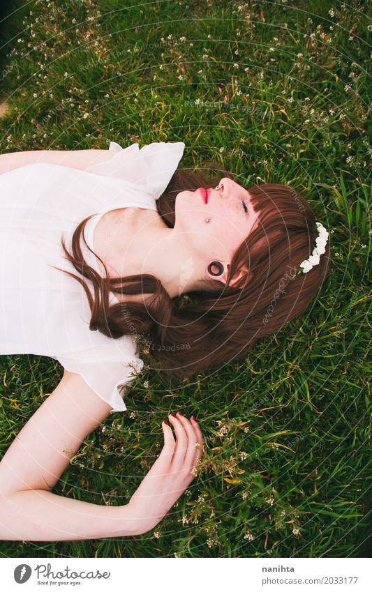 Young brunette woman sleeping over a field of grass Lifestyle Elegant Beautiful Wellness Harmonious Well-being Relaxation Calm Meditation Freedom Human being